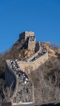 pexels-photo-36799360-36799360 Crowds of tourists explore the iconic Great Wall of China under a clear blue sky.