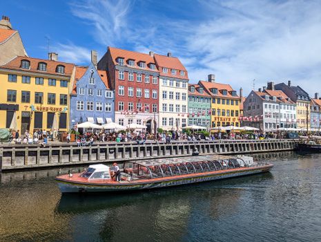 pexels-photo-35276893-35276893 Vibrant canalside view of Nyhavn's colorful historic houses and tourist boats in Copenhagen, Denmark.